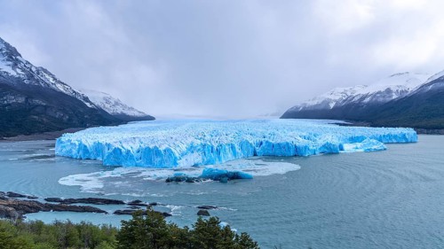 Perito Moreno glacier with glowing blue ice front, Lake Argentino surrounded by snow-capped