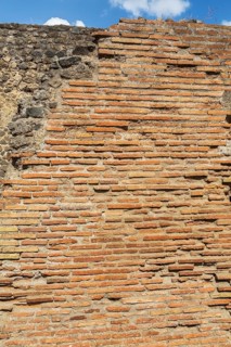 Close-up of old terracotta brick and stone wall at the ancient ruins of Pompeii, Campania region,