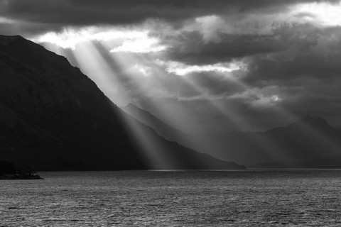 Black and white image of sunbeams and light mood at sunset at Lago Huechulafquen, Lanin National