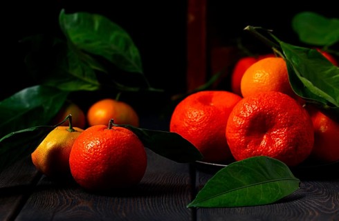 Fresh tangerines with leaves, close-up, on a wooden table, horizontal, no people