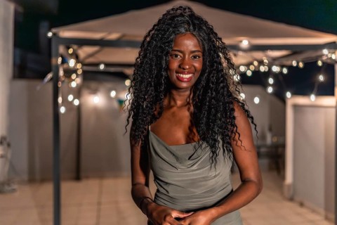 Portrait of a beauty african woman standing smiling at camera in a night roof party