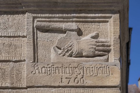 Relief of a chopped-off hand and an executioner's axe on the baroque Blue House, built around 1765,
