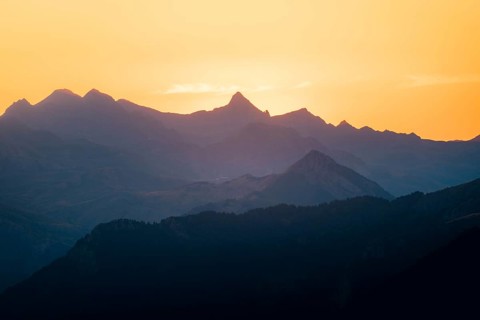 Serene image capturing silhouette of mountains at golden sunset in the Pyrenees. Layers of peaks