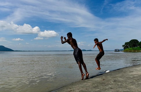 Boys jump in the Brahmaputra river during an a hot summer day in Guwahati, india on July 11, 2022