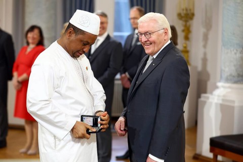 Aliou Barry Guinea looks at his mobile phone while Frank-Walter Steinmeier (President of the