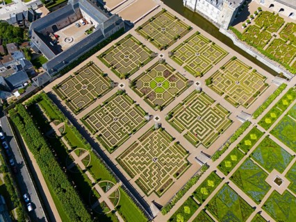 Geometric gardens with manicured paths, symmetrically arranged as part of a castle complex, aerial