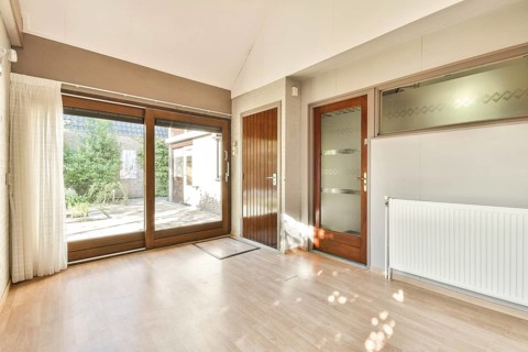 A spacious interior featuring large windows that invite ample natural light, highlighting a
