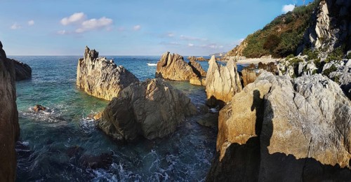 Craggy rocks jutting out of the sea on the beach of Lido La Scogliera, Tropea, Vibo Valentia,