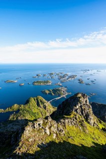 View of numerous small rocky islands with houses, at the summit of Festvågtind, view of