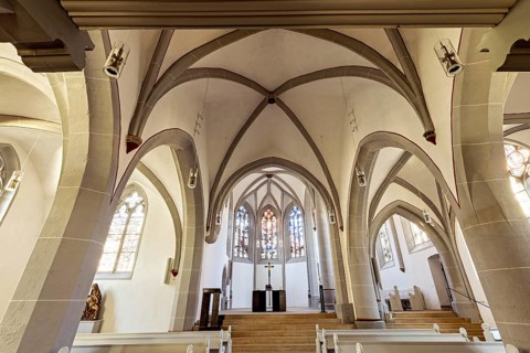 Interior of a Gothic church with high arches, windows and altar, flooded with light, The cross