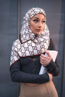 Portrait of an Arab girl with a white veil at the computer on the terrace of a coffe shop