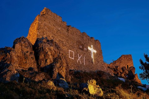 Castle ruins at night with illuminated cross, rocky surroundings, historical ambience, Archangelos,