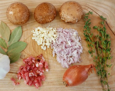 Ingredients on wooden board, preparation, mushrooms, dried bay leaves, onions, garlic cloves,