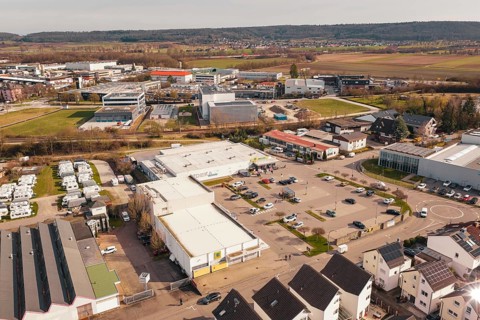 Industrial area with shopping center and fields in the background, under clear sky, Gärtringen,