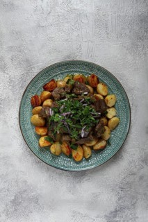Kuyrdak, roast offal with potatoes and fresh herbs, homemade in Kazakh, no people