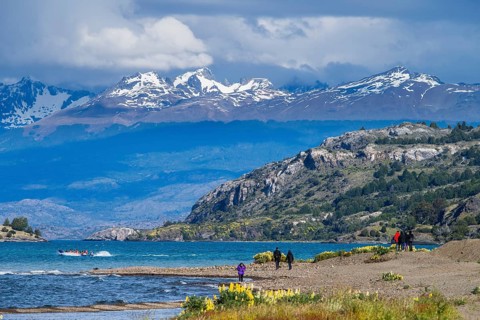 Walkers, tourists on the beach of the lake Lago General Carrera, also Lago Chelenko, snow-covered