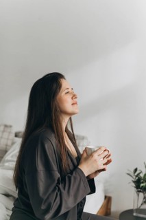 A woman enjoys a quiet moment with a cup of tea, reflecting on wellness and healthy living. This