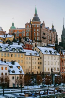 Experience the charm of Stockholm with this image of snow-adorned historical architecture. The