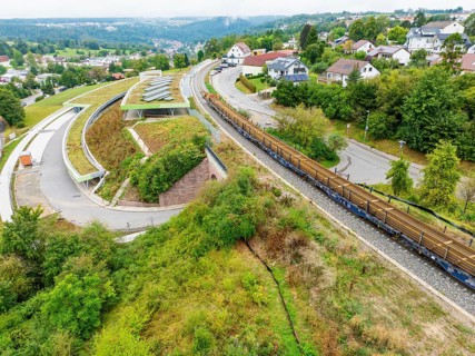 Railway tracks run through a green residential area from an aerial view, track construction, rail