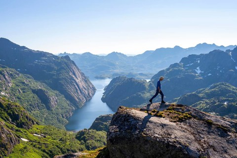Mountaineer, young man hiking in front of mountain landscape, fjord Trollfjord and mountains, hike