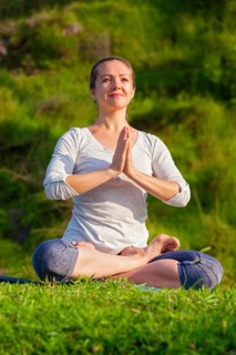Meditation and relaxation yoga outdoors, young woman meditating and relaxing in Padmasana Lotus