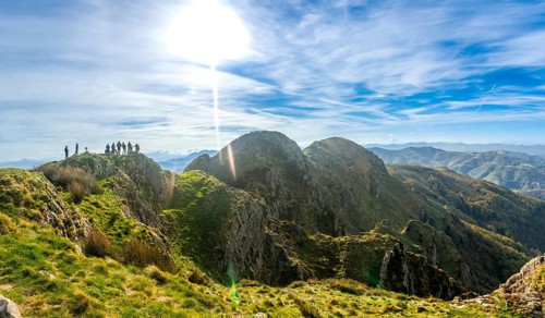 Group of hikers standing on the peak of aiako harria mountain enjoying the stunning view of the