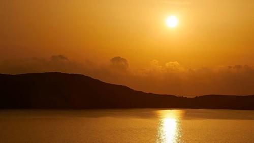 An intense sunset with silhouettes of hills with orange tones dominating, Navarino Bay, Pylos,