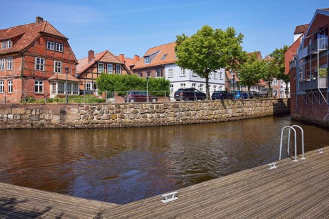 River Schwinge with jetty, half-timbered houses, residential buildings and street in Stade,