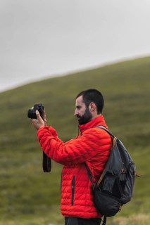 A traveler in a red jacket captures stunning photos on a road trip through Norway's scenic