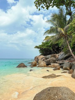 Serene beauty of a secluded beach in Phuket, Thailand, featuring clear turquoise waters, golden