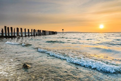 Golden sunrise on the shore of Lake Constance with jetty near Altnau in the canton of Thurgau,
