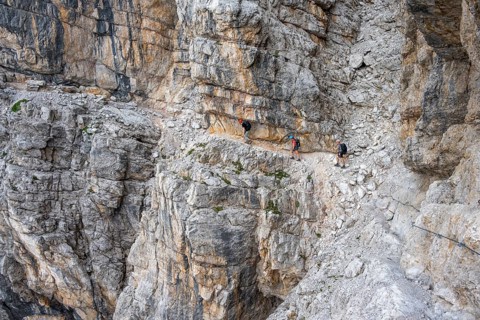 Three hikers on the Via Ferrate Benini via ferrata on a cliff, Brenta Mountains, Parco Naturale