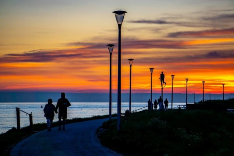 Sunset on the beach of Zoutelande, people on the dike, Zeeland, Netherlands