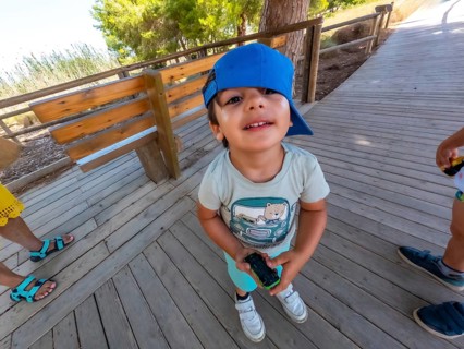 Young child holding a toy car while enjoying a sunny day at the natural park of las lagunas de la