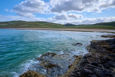 Rocky coastal landscape with soft waves and cloudy sky, Farr Bay, Bettyhill, Thurso, Scotland,
