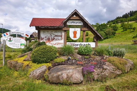 Tourist information sign climatic health resort, flower bed with natural stones, hilly landscape,
