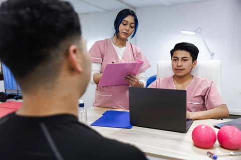 Medical professionals in a physiotherapy clinic in Ecuador consult with a patient. The setting