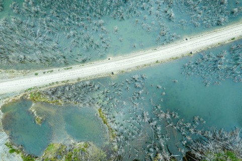 Flooded forest with dead trees, river Rio Norte damned by landslide, new road passing new created