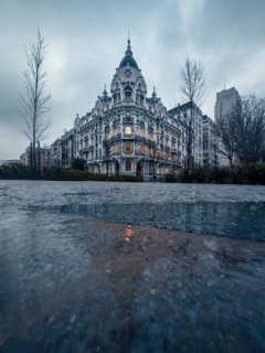 Elegant historic building of Madrid with ornate facade and soft warm lighting at dusk. A tranquil,
