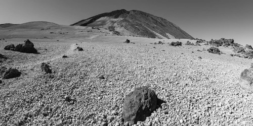 Hiking trail and rock formations, volcanic landscape in El Teide National Park, behind it the Pico