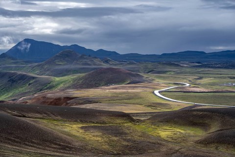 Road through volcanic landscape with colourful hills, Krafla geothermal area, Northern Iceland,
