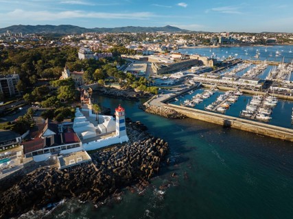 Aerial view of Santa Marta lighthouse and Cascais marina with moored yacht boats with Cascais