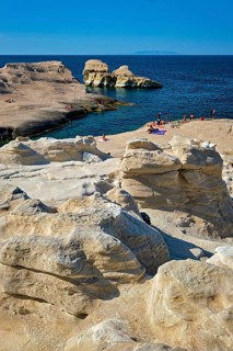 White rocks of famous tourist attraction of Milos island Sarakiniko beach with tourist relax and