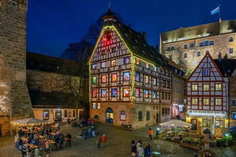 Historic Pilatus House in the evening with an Advent calendar designed by the Altstadtfreuden