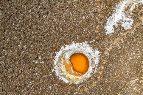 Top view, aerial capture of a vibrant orange and white salt formation embedded in the textured