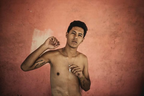 A boy smokes a cigarrette at the grave of the social bandit Malandro Ismael, Cementerio General del