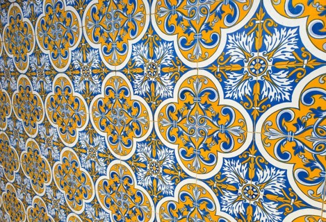 Decorative tiles with blue and yellow patterns on a wall, showing a traditional and symmetrical