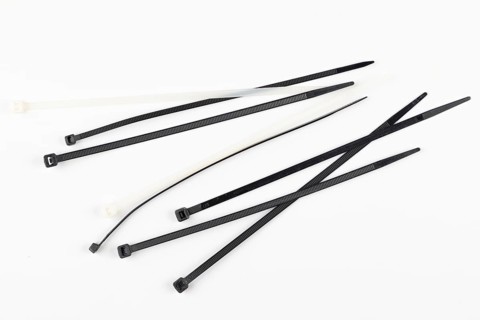 Several black and white cable ties lie loose on a white background