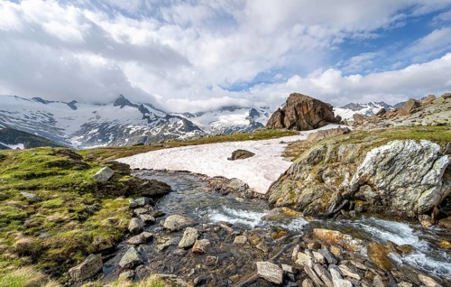 Picturesque mountain landscape with mountain stream Zemmbach, mountain peaks with snow and glacier