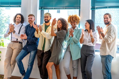 Portrait of a cheerful team of young and multiracial cowokers celebrating while applauding